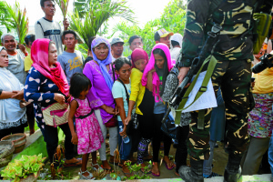 A soldier stands beside voters waiting for their turn to cast votes outside a polling center in Shariff Aguak Elementary School in Shariff Aguak town in Maguindanao.PHOTO BY JEOFFREY MAITEM / INQUIRER MINDANAO 