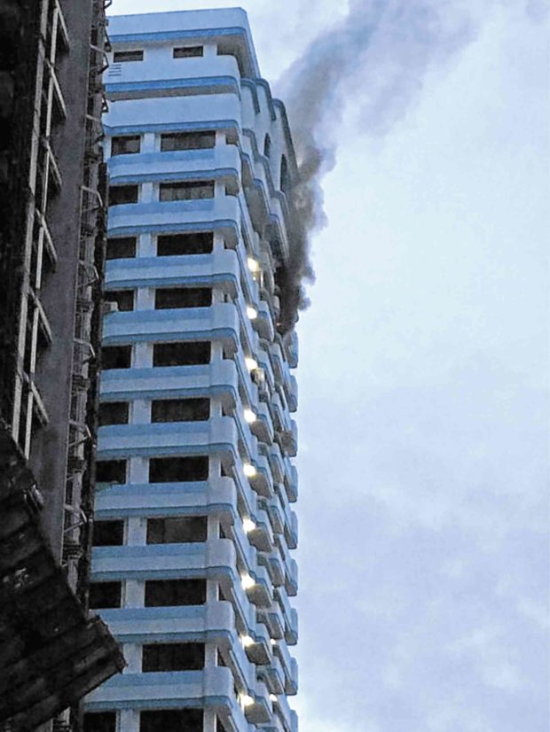 HIGH-RISE ROUSER A plume of smoke rises from the 19th floor of a Parañaque City condo building where a fire broke out early Friday morning.   Eljohn Obsequio/ @eljohnobsequio, contributor