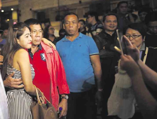 WOMEN’S RIGHTS VIOLATOR?  Presumptive President-elect Rodrigo Duterte, cited by the Commission on Human Rights for violating women’s rights, poses with a woman after his press conference at a hotel in Davao City on Thursday. JEOFFREY MAITEM/INQUIRER MINDANAO