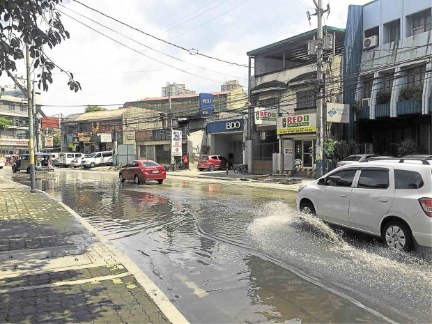 NOT AGAIN  Mandaluyong residents said the ankle-deep water on Maysilo Circle was from the previous night’s rain and was still there when this photo was taken around 2 p.m. on Friday. JOVIC YEE