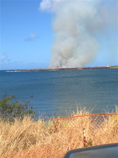 In this photo provided by Ryan Richardson, plumes of smoke are seen from Port Allen Harbor across an inlet after a plane crashes just outside Port Allen Airport on the island of Kauai, on Monday, May 23, 2016. Multiple people died after a skydiving tour plane crashed and caught fire in Hawaii, one of two plane crashes reported Monday in the islands. (Ryan Richardson via AP)