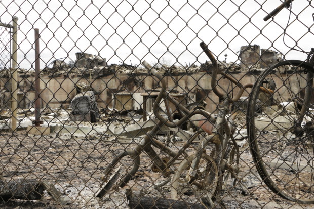 Bicycles lean against a fence in front of burned townhouses in Fort McMurray, Alberta, following a massive wildfire, Monday, May 9, 2016. A break in the weather has officials optimistic they have reached a turning point on getting a handle on the massive wildfire. (AP Photo/Rachel La Corte)