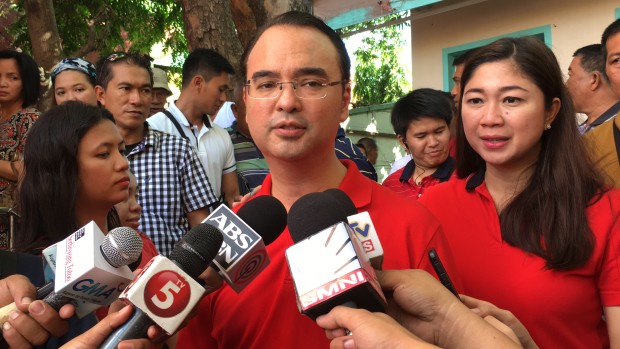 Caption: Senator Alan Peter Cayetano, left, with wife and mayor Lani, speaks to the media after casting his ballot at Sta. Teresa Elementary School in Barangay Bagumbayan, Taguig City.