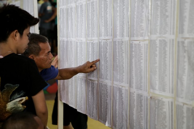 A man is seen trying to finding his precinct number. Photo by Tristan Tamayo/INQUIRER.net