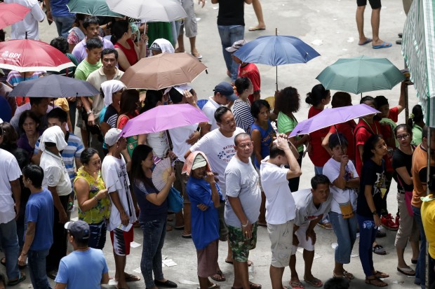 Votes whip out their umbrellas as they wait in line to vote. Photo by Tristan Tamayo/INQUIRER.net