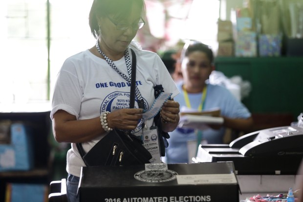 A woman looking at her voting receipt before putting it a designated box. Photo by Tristan Tamayo/INQUIRER.net 
