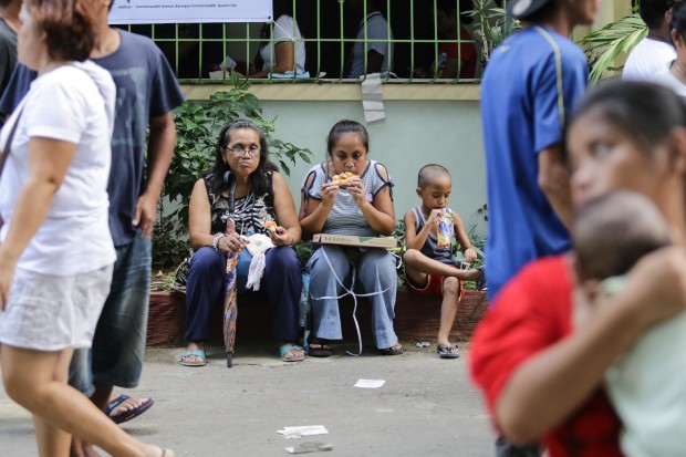 A family grabs a bite before making their way out of the voting area. Photo by Tristan Tamayo/INQUIRER.net