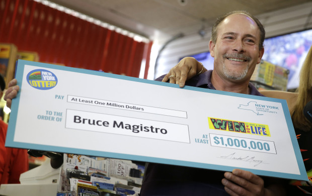 Bruce Magistro holds up a check while talking to reporters about winning $1 million in the New York Lottery for a second time  during a news conference in Babylon, N.Y., Wednesday, May 11, 2016. Lottery officials revealed Magistro  as the two-time lottery winner.   (AP Photo/Seth Wenig)