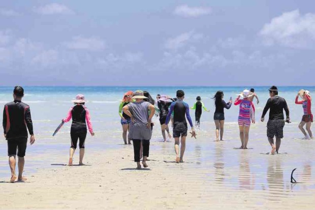 VISITORS walk on the sandbar that has earned the name “vanishing island,” during low tide in Salvacion village in Malilipot town, Albay province.       MARC ALVIC ESPLANA/INQUIRER SOUTHERN LUZON