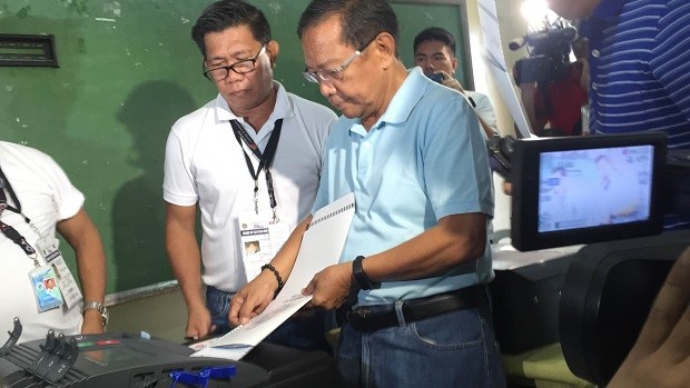 Vice President Jejomar Binay on Monday feeds his ballot to the vote counting machine at San Antonio National Highschool in Makati. MARC JAYSON CAYABYAB/INQUIRER.net