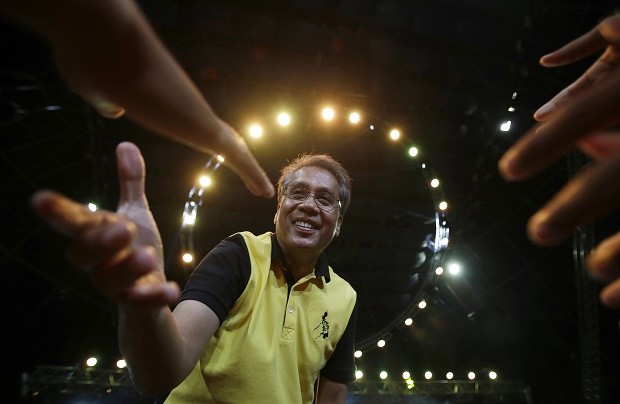 In this April 28, 2016, file photo, Philippine Presidential Mar Roxas, former Interior and local government secretary, reaches out to greet supporters during a campaign sortie in suburban Quezon city, north of Manila, Philippines. A U.S.-educated investment banker and the richest Philippine presidential aspirant, Roxas lacks the dramatic life stories of his rivals, including a tough-talking mayor with a public vow to dump criminals in Manila Bay and a foundling who made it big in politics. AP FILE PHOTO