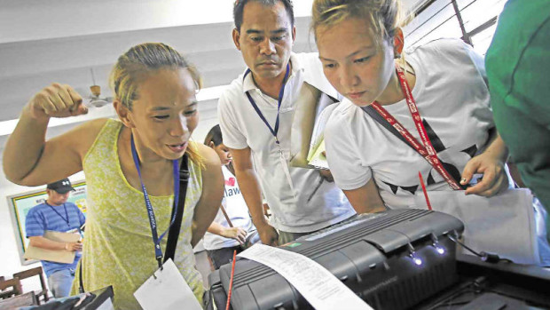 WATCHING COUNT    Poll watchers  scrutinize the vote tally at Maximo Estrella Elementary School in Makati City.  KIMBERLY DELA CRUZ