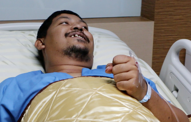 In this image made from video, Attaporn Boonmakchuay gestures while talking to reporters, while lying in a hospital bed following a snake attack at his home in Chachoengsao, 90km east of the capital Bangkok, Wednesday, May 25, 2016. Boonmakchuay is recovering from a bloody encounter with a 3-meter (10-foot) python that slithered through the plumbing of his home and latched its jaws onto his penis as he was using a squat toilet. (BBTV CH7 Thailand via AP) 