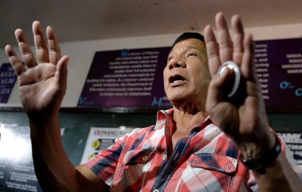 Presidential frontrunner and Davao City Mayor Rodrigo Duterte gestures as he arrives at the voting precint to cast his vote at Daniel Aguinaldo National High School in Davao City, on the southern island of Mindanao on May 9, 2016. Voting was underway in the Philippines on May 9 to elect a new president, with anti-establishment firebrand Rodrigo Duterte the shock favourite after an incendiary campaign in which he vowed to butcher criminals. / AFP PHOTO / NOEL CELIS