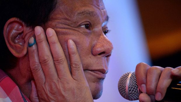 Presidential frontrunner and Davao City Mayor Rodrigo Duterte attends a press conference after he cast his vote in Davao City, on the southern island of Mindanao on May 9, 2016. Voting was underway in the Philippines on May 9 to elect a new president, with anti-establishment firebrand Rodrigo Duterte the shock favourite after an incendiary campaign in which he vowed to butcher criminals. / AFP PHOTO / NOEL CELIS
