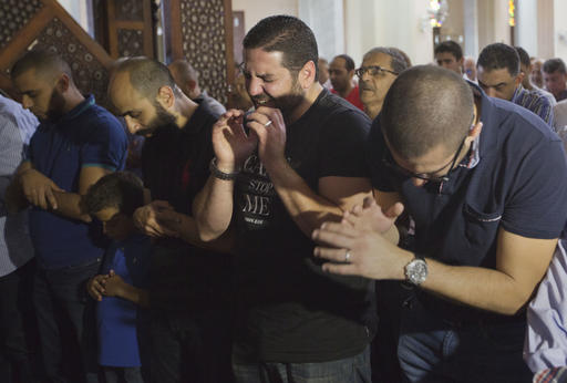 Tarek Abu Laban, center, who lost four relatives, all victims of Thursday's EgyptAir plane crash, attends prayers for the dead, at al Thawrah Mosque, in Cairo, Egypt, Friday, May 20, 2016. The Airbus A320 plane was flying from Paris to Cairo with 66 passengers and crew when it disappeared early Thursday over the Mediterranean Sea. AP PHOTO
