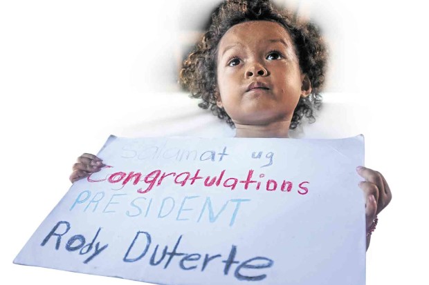 A “LUMAD” child in an evacuation center in Davao City displays a congratulatory note for presumptive President Rodrigo Duterte. KARLOS MANLUPIG/INQUIRER MINDANAO