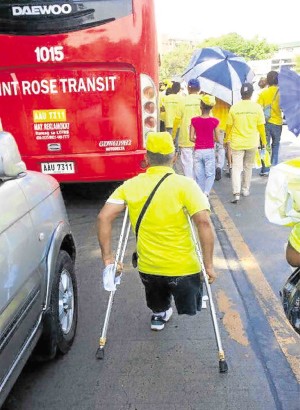 DRESSED in yellow to show his support, a disabled man joins the unity walk for LP bets Roxas-Robredo. JING NAGUIAT/oras na, roxas na Facebook page