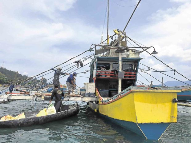 CREW members of fishing boat FB JJM arrive in Subic, Zambales province after a weeklong fishing trip in Scarborough Shoal. The fishermen said the once hostile Chinese coast guards grew tired of driving them away from the disputed shoal, easing the tension in that rich fishing ground.   ALLAN MACATUNO/INQUIRER CENTRAL LUZON