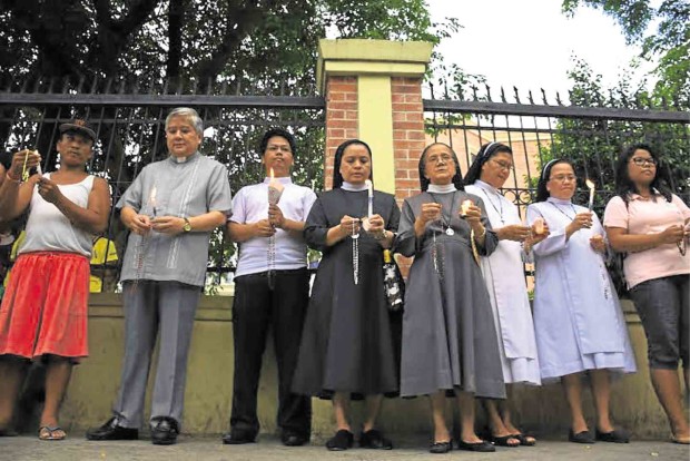 FOR PEACEFUL POLLS Lingayen-Dagupan Archbishop Socrates Villegas (second from left), president of the Catholic Bishops’ Conference of the Philippines, leads a group of church workers and parishioners in Dagupan City in prayers and a candle lighting ceremony for clean and peaceful elections.    WILLIE LOMIBAO / Inquirer Northern Luzon 