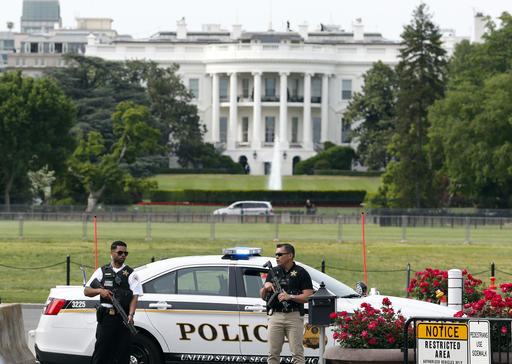 Law enforcement personnel stand near the Ellipse south of the White House on Constitution Avenue, Friday, May 20, 2016 in Washington. A uniformed Secret Service officer shot a person who drew a weapon just outside the White House Friday afternoon, a U.S. law enforcement official said. AP PHOTO