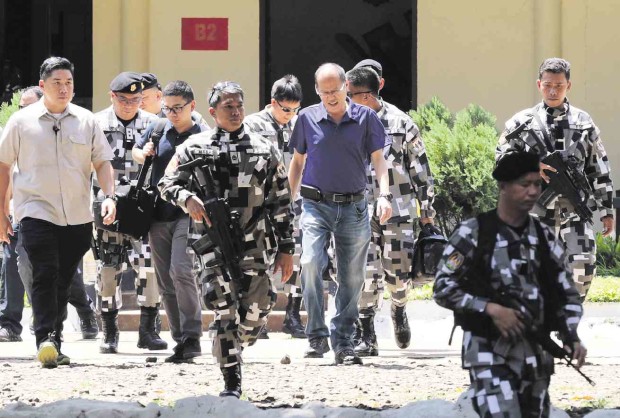 GOING AFTER THE KILLERS  Under heavy guard, President Aquino arrives at Camp Teodulfo Bautista in Busbus, Jolo, Sulu province, on Wednesday to preside over a top-level security meeting. GRIG C. MONTEGRANDE 