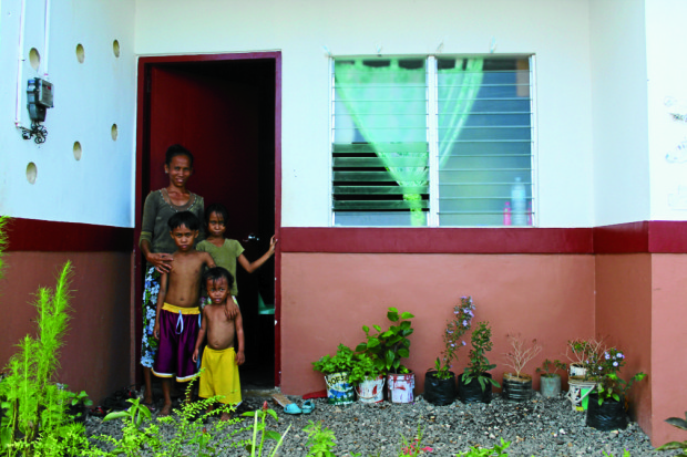 NEW HOME Beverlyn Vergara, who lost her house to Supertyphoon “Yolanda” in 2013, poses with three of her four children in their new home, one of 64 built for families who lost their homes during the typhoon.