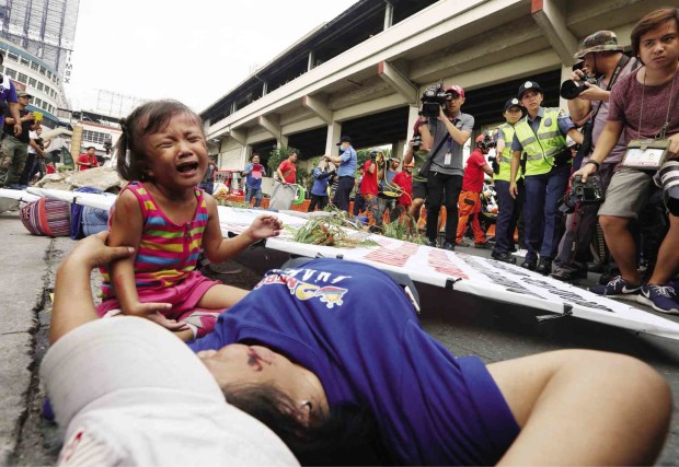 EARTHQUAKE DRAMA A girl cries as her mother acts as an injured victim on Guadalupe Bridge in Makati City during the nationwide earthquake drill on Wednesday.  Metro Manila authorities declared the exercise a success. The drill drew more than 6.5 million participants. NIÑO JESUS ORBETA 