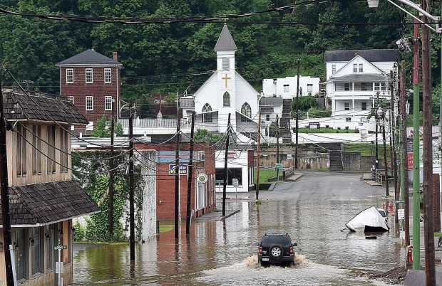 A vehicle makes a wake along the flooded Lower Oakford Ave. Friday, June 24, 2016, in Richwood, W.Va. Rick Barbero/The Register-Herald