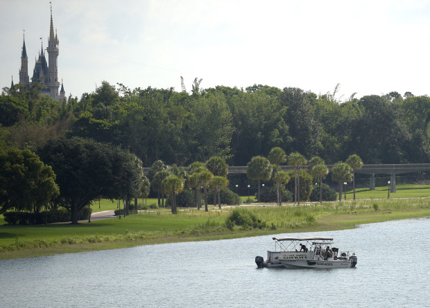 Orange County Sheriff's officers search the Seven Seas Lagoon between Walt Disney World's Magic Kingdom theme park, left, and the Grand Floridian Resort & Spa on Wednesday, June 15, 2016, in Lake Buena Vista, Fla., after a two-year-old toddler was dragged into the lake by an alligator. (AP Photo/Phelan M. Ebenhack)