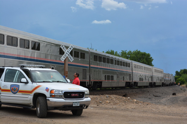 A member of the Fisher's Peak Fire Department watches an Amtrak train after it cllided with a minivan at a crossing east of Trinidad, Colo., Monday, June 27, 2016. A 4-year-old girl was the only member of her family to survive after their minivan was hit by the Amtrak train at the crossing with a history of problems in southern Colorado, authorities said. (Eric John Monson/The Trinidad Chronicle News via AP) MANDATORY CREDIT
