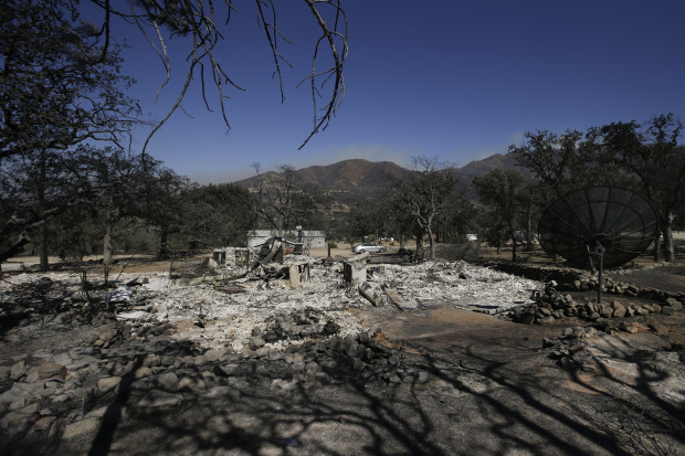 Scorched trees and debris are all that remains of a home burned by a wildfire Friday, June 24, 2016, in Mountain Mesa, Calif. (AP Photo/Jae C. Hong)
