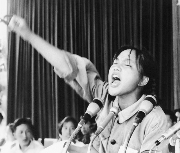FILE - In this file photo taken Aug. 10, 1966, a young woman identified only as Ms. Zhou calls out to embolden her fellow Red Guards in Beijing’s Tiananmen Square at the start of the 1966-76 Cultural Revolution. Monday, May 16, 2016 marks the 50th anniversary of a 1966 party meeting that spearheaded the 10-year Cultural Revolution, a violent and frequently chaotic attempt by Mao to reassert his power and revive his party’s egalitarian ideals.  (AP Photo, File)