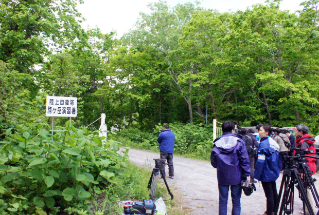 Media members gather near a military drill area in Shikabe town, on the northernmost main island of Hokkaido Friday, June 3, 2016. The 7-year-old Japanese boy who went missing nearly a week ago after his parents left him in a forest as punishment was found unharmed Friday morning by a soldier in the military drill area, police said, in a case that had set off a nationwide debate about parental disciplining. (Kyodo News via AP) JAPAN OUT, MANDATORY CREDIT
