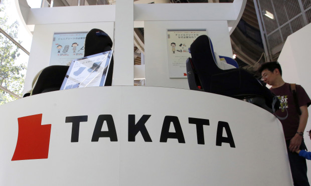 FILE - In this May 4, 2016 file photo, visitors look at child seats, manufactured and displayed by Takata Corp. at an automaker's showroom in Tokyo. A Malaysian safety official says a woman has died after the airbag in her Honda Civic ruptured in a minor collision. The incident Sunday, June 26 came days after Honda Malaysia announced an additional recall of more than 145,000 vehicles to replace defective front passenger airbag inflators. (AP Photo/Shizuo Kambayashi, File)