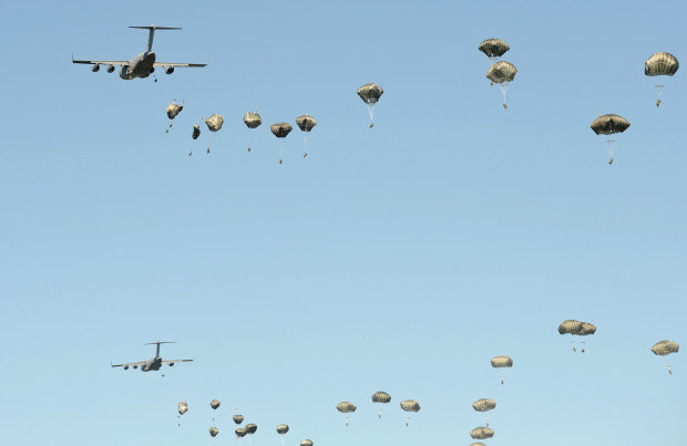 U.S. C-17 planes from the 82nd Airborne Division drop paratroopers during a multi-national jump with soldiers and equipment from the U.S., Great Britain and Poland on to a designated drop zone near Torun, Poland, Tuesday, June 7, 2016. The exercise, Swift Response-16, sets the stage in Poland for the multi-national land force training event Anakonda-16. (AP Photo/Alik Keplicz)