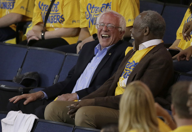 FILE - In this May 30, 2016 file photo, Democratic presidential candidate Sen. Bernie Sanders, I-Vt., left, laughs with actor Danny Glover during Game 7 of the NBA basketball Western Conference finals between the Golden State Warriors and the Oklahoma City Thunder in Oakland, Calif. Hes lagging in delegates and votes, but Sanders is still on one excellent campaign adventure. In the past few months the Vermont Senator and his wife, Jane, have traveled to Rome to see Pope Francis and dropped in on the final game of the NBAs Western Conference finals. (AP Photo/Ben Margot, File)