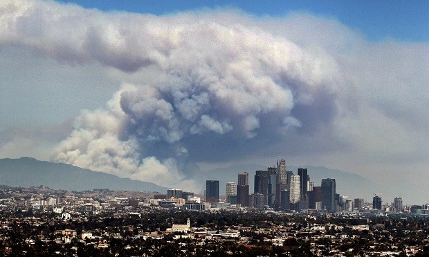 Smoke from wildfires burning in Angeles National Forest fills the sky behind the Los Angeles skyline on Monday, June 20, 2016. The wildfires several miles apart devoured hundreds of acres of brush on steep slopes above foothill suburbs erupted in Southern California as an intensifying heat wave stretching from the West Coast to New Mexico blistered the region with triple-digit temperatures. (AP Photo/Ringo H.W. Chiu)