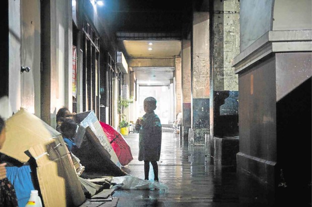 A YOUNG boy takes shelter inside the Baguio public market, along with indigenous peoples who had been begging in Baguio City, during a storm in May 2015.             RICHARD BALONGLONG/INQUIRER NORTHERN LUZON
