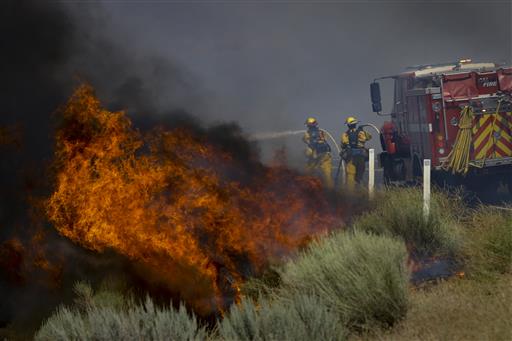 Firefighters battle a wildfire burning along Highway 178 near Lake Isabella, Calif., Friday, June 24, 2016. The wildfire that roared across dry brush and trees in the mountains of central California gave residents little time to flee as flames burned homes to the ground, propane tanks exploded and smoke obscured the path to safety. AP Photo