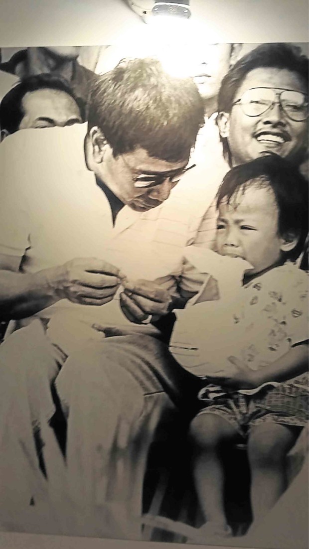 ONE OF the earliest pictures taken of Duterte by Lumawag is this one showing the then first term mayor looking after a boy, Toperjay Pore Quijano, now a grown man, who got lost in Rizal Park in Davao City and was noticed by Duterte. RENE LUMAWAG