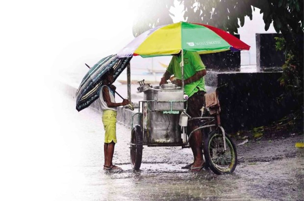 HEAVY rain does not stop this child from running to his favorite ice cream vendor in Sto. Domingo town, Albay province, one of the areas tagged by the Mines and Geosciences Bureau as prone to flood when La Niña strikes.  SHAN GABRIEL APULI/INQUIRER SOUTHERN LUZON