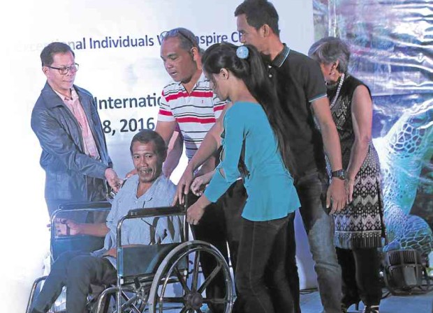 NORMAN Pagal (in wheelchair), of Barangay Anapog in San Remigio town, Cebu province, receives the Ocean Heroes Award for his unflinching commitment to the task of watching the seas for signs of illegal fishing. FERDINAND EDRALIN/CEBU DAILY NEWS
