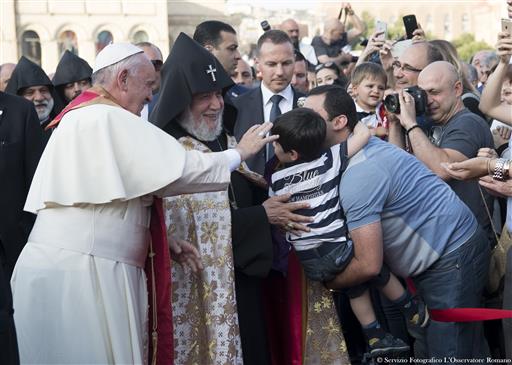 Pope Francis and Catholicos Karekin II, right, reach out to touch a child during an Ecumenical encounter and prayer for Peace in Yerevan's Republic Square, Armenia, Saturday, June 25, 2016. AP