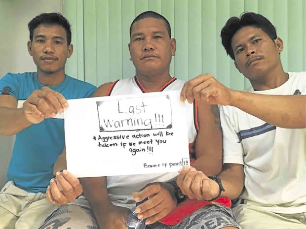 FISHERMEN (from left) Teody Baisa, Nelson Plamiano and Arlon Sandro show a note, given by a Malaysian Navy personnel, warning them against fishing near the Rizal Reef. ALLAN MACATUNO / INQUIRER CENTRAL LUZON 