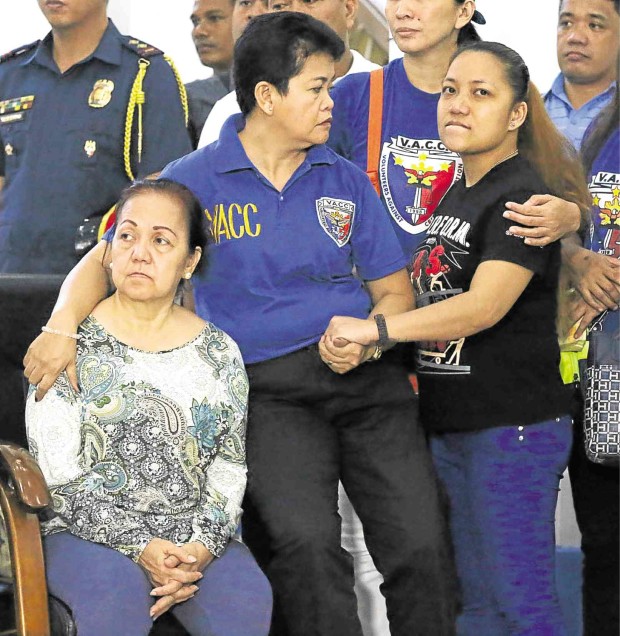 Malou Garalde (left), mother of road rage victim Mark Vincent Garalde, and his widow Rei (right) are comforted by a member of the Volunteers Against Crime and Corruption at the Manila Police District headquarters on Saturday. MARIANNE BERMUDEZ