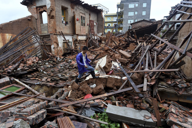 In this July 9, 2016 photo, a villager walks around a destroyed house, after torrential rainfall brought by typhoon Nepartak, in Lingcuo village of Xindu Township in Putian, southeast China's Fujian Province.  Typhoon Nepartak weakened to a strong tropical storm Saturday as it lashed China's east coast, bringing powerful winds and heavy rains that toppled houses and inundated roads. (Zhang Guojun/Xinhua News Agency via AP)