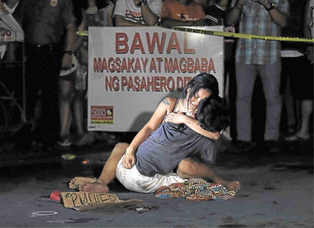 LAMENTATION A weeping Jennelyn Olaires hugs partner Michael Siaron, 30, a pedicab driver and alleged drug pusher, who was shot and killed by motorcycle-riding gunmen near Pasay Rotonda on Edsa. He was one of six killed in drug-related incidents in Pasay and Manila yesterday. RAFFY LERMA 