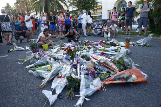 People pay tribute to the victims at the site of a deadly truck attack on the famed Promenade des Anglais in Nice, southern France, Saturday, July 16, 2016. French Interior Minister Bernard Cazeneuve says that the truck driver who killed 84 people when he careened into a crowd at a fireworks show was "radicalized very quickly." (AP Photo/Francois Mori)