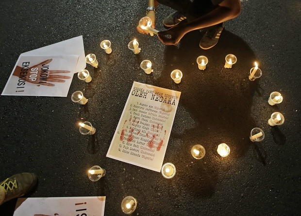 An activist lights candles arranged around a poster containing the names of death row inmates who are facing imminent executions during a vigil against death penalty outside the presidential palace in Jakarta, Indonesia, Thursday, July 28, 2016. Indonesia rebuffed appeals from distraught relatives, rights advocates and foreign governments to abandon plans to execute the 14 people for drug crimes as preparations intensified at the prison island holding the inmates. Writings on the poster read: "Those who are about to be killed by the state" and "Jokowi (popular nickname of Indonesian President Joko Widodo), stop the executions!". AP 